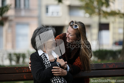 Image of Elderly old cute woman with Alzheimer's very happy and smiling when eldest daughter hugs and takes care of her