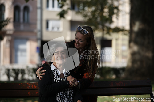 Image of Elderly old cute woman with Alzheimer's very happy and smiling when eldest daughter hugs and takes care of her