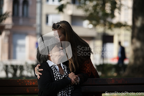 Image of Elderly old cute woman with Alzheimer's very happy and smiling when eldest daughter hugs and takes care of her