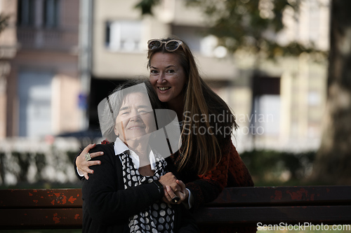 Image of Elderly old cute woman with Alzheimer's very happy and smiling when eldest daughter hugs and takes care of her