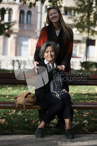 Image of Elderly old cute woman with Alzheimer's very happy and smiling when eldest daughter hugs and takes care of her