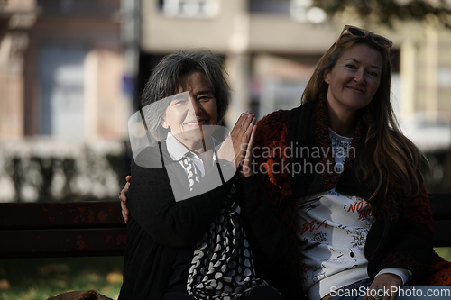 Image of Elderly old cute woman with Alzheimer's very happy and smiling when eldest daughter hugs and takes care of her