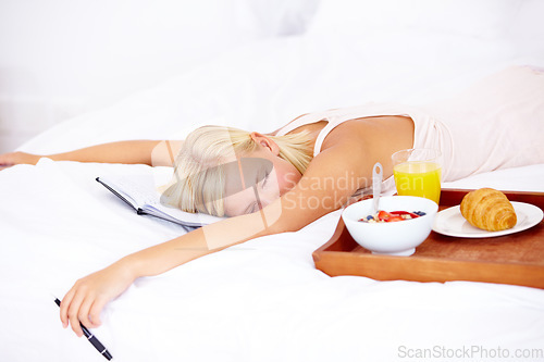 Image of Woman, bed and notebook with breakfast, sleep and tired with diary, bedroom and journaling. Food, fruits and croissant with orange juice, nutrition and healthy diet in home, rest and morning