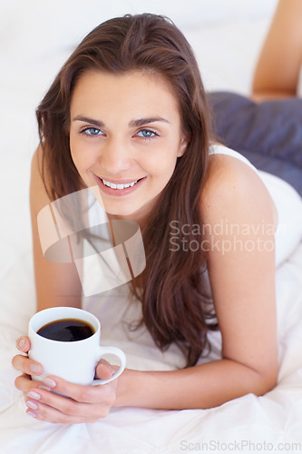 Image of Coffee, bed and portrait of happy woman in morning, wake up or natural wellness in home on calm summer weekend. Relax, drink and peace, smile on face and girl in apartment, bedroom or house with rest