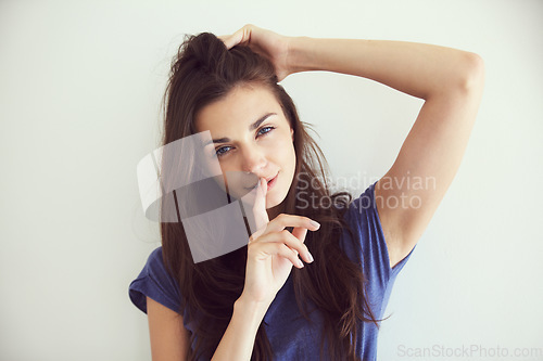 Image of Portrait, woman and finger on the lips with a secret, emoji and gossip on white studio background. Face, person and model with privacy, whisper or confidential information with body language or shush