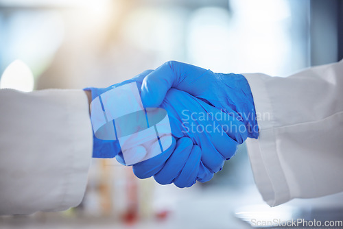 Image of Science, handshake and agreement in laboratory for success, deal or gratitude. Teamwork, medical research and scientist shaking hands in gloves for partnership, collaboration or welcome for doctors.