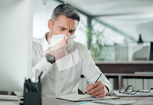 Image of Business man blowing nose at desk in office for allergies, cold and sick virus while writing in notebook. Mature entrepreneur with tissue for infection, influenza or allergy risk while planning notes