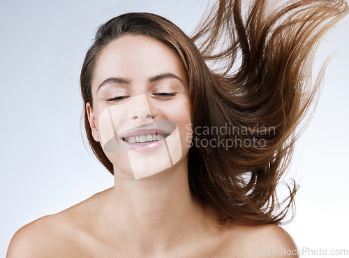 Image of Hair care, woman or face and smile in studio with breeze, collagen treatment or brazilian for shine. Person, happy and cosmetics with dermatology, keratin or beauty with white background for wellness