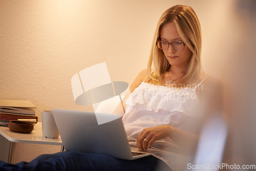 Image of Woman, laptop and journalist in relax on chair typing, reading or writing in living room at home. Calm female person, freelancer or typist in remote work on computer for online connection at house