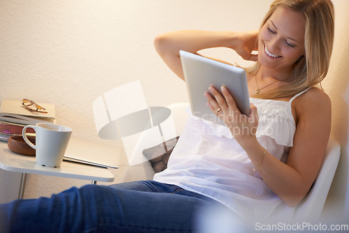 Image of Happy woman, tablet and relax on chair for social media, streaming or entertainment in living room at home. Female person smile with technology for online search, communication or networking at house