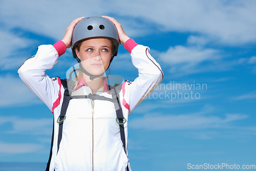 Image of Woman, skydiver and helmet in outdoors, adventure and recreation or extreme sports for fun or equipment. Female person, travel and outside or fitness, holiday and vacation or getaway by blue sky