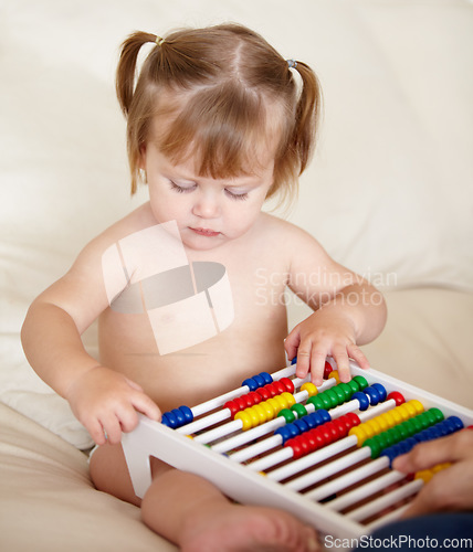 Image of Learning, child development and a girl baby with an abacus in the bedroom of a home for growth. Kids, education or math with an adorable and curious young toddler counting on a bed in an apartment