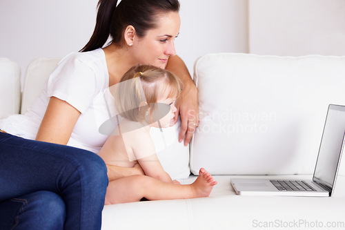 Image of Family, laptop or streaming with a mom and baby on a sofa in the living room of a home for entertainment. Computer, movie or childcare with a woman parent and toddler girl in an apartment together