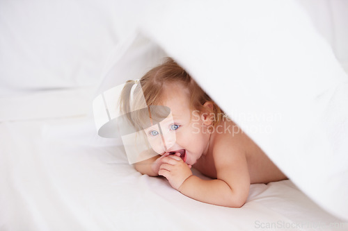 Image of Home, growth and child development with a baby in the bedroom to relax alone in the morning. Happy, kids or youth and an adorable young infant girl on a bed with blankets for comfort in an apartment