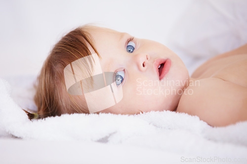 Image of Portrait, growth and child development with a baby in the bedroom to relax alone in the morning. Face, kids or youth and an adorable young infant girl on a bed with blankets for comfort in a home