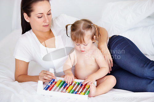 Image of Family, learning or abacus with a mother and baby on a bed in their apartment together for child development. Growth, education or math and an infant girl counting with her parent in a home bedroom