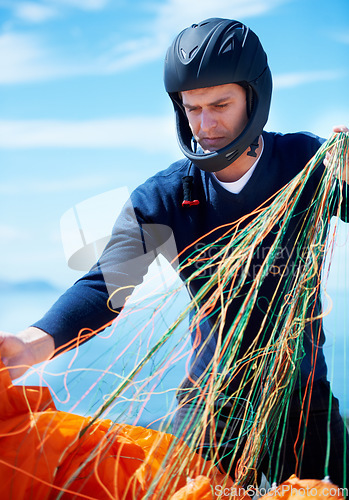 Image of Paragliding, parachute or man with strings in nature in preparation, exercise or health support. Young person, fitness or wellness for outdoor with safety harness, helmet or adventure in countryside