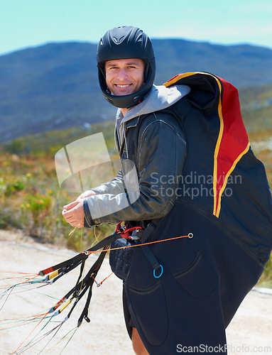 Image of Paragliding, parachute or man in nature in portrait, smile or strings for exercise for health support. Athlete, face and training with happy for outdoor fitness, helmet and equipment in countryside