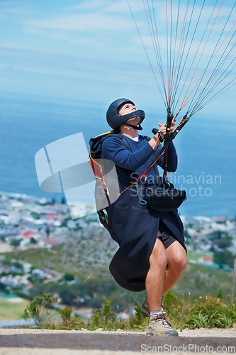 Image of Man, parachute and paragliding launch in air in nature, healthy adventure and fun in extreme sport. Athlete, take off or fearless for outdoor fitness for wellness, helmet or safety gear by blue sky