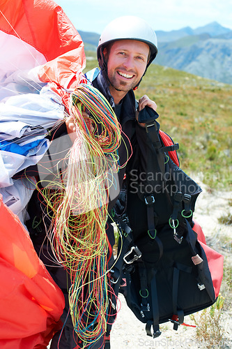 Image of Paragliding, parachute or man in nature for portrait, happy or strings for training for flight preparation. Athlete, face or smile for fitness for outdoor wellness, helmet or equipment in countryside