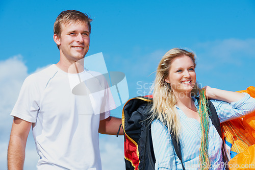 Image of Paragliding, parachute and man with woman in nature in health fitness, wellness and love in support. Young couple, happy and outdoor together with safety harness, smile and adventure in countryside