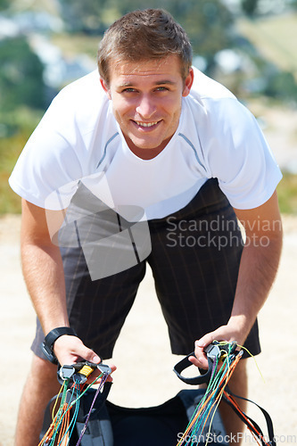 Image of Paragliding, parachute or man in sport for portrait, smile or strings for exercise for flight preparation. Athlete, face or happy with fitness for outdoor wellness, helmet or equipment in countryside