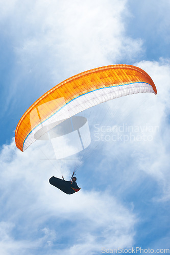 Image of Man, parachute and paragliding in blue sky for flight, freedom and courage with extreme sport. Athlete, glide and fearless in outdoor fitness for adventure, health and sports by ocean with mountain