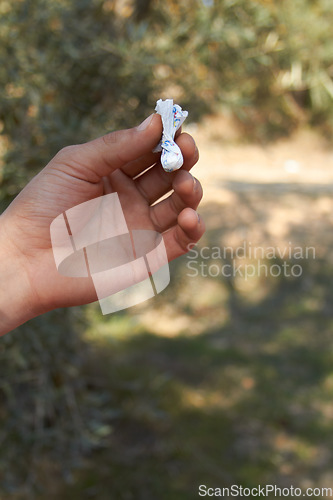 Image of Hand, packet and drugs outdoor in forest for cocaine, recreation or unhealthy habit with package. Person, powder or holding paper with pharmaceutical, illegal and trees for party, event or social