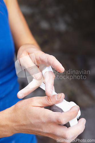 Image of Person, hands and rock climbing or finger tape as grip strength, injury or support. Athlete, fingers and band aid or rope challenge or danger adventure on stone cliff or train gear, brave on mountain