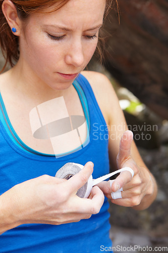 Image of Woman, hands and rock climbing or finger tape as grip strength, injury or support. Female person, band aid for safety rope challenge or danger adventure on stone cliff gear, brave risk on mountain