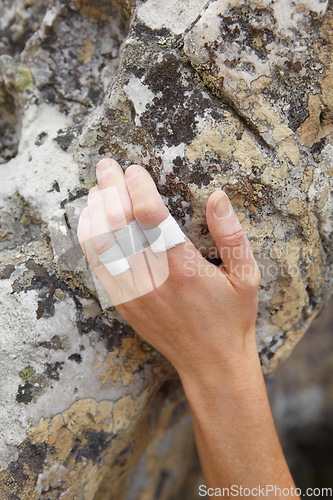 Image of Person, mountain and rock climbing or finger tape on hand for exercise injury, sports grip on nature cliff. Athlete, boulder and hanging for explore peak practice for brave adventure, risk or strong