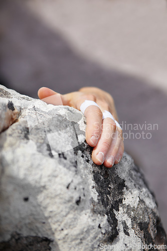 Image of Person, grip and rock climbing or finger tape on hand for exercise injury, sports pain on nature cliff. Athlete, boulder and hanging for explore peak practice for brave adventure, risk on mountain