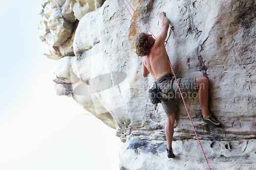 Image of Man, rock climbing and mountain rope adventure or sports challenge, risk performance on stone crack. Male person, hanging and outdoor cardio gear or courage as fearless athlete, brave danger on cliff