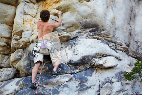 Image of Man, rock climbing and rope hanging on mountain boulder for challenge, risk performance on stone. Male person, exercise and outdoor cardio gear or courage as fearless athlete, brave danger on cliff