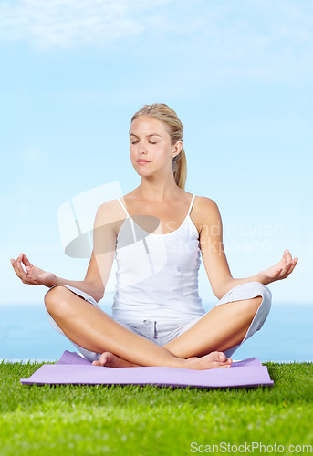 Image of Woman, lotus pose and meditation in park for peace, calm and mental health or wellness and mindfulness. Young and zen person relax with outdoor yoga, spiritual care and chakra on blue sky background