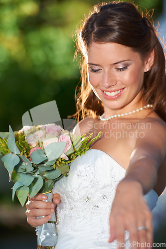 Image of Happy woman, bride and bouquet of flowers at wedding for marriage, love or commitment at outdoor ceremony. Married female person smile with floral roses in beauty or dress for celebration in nature