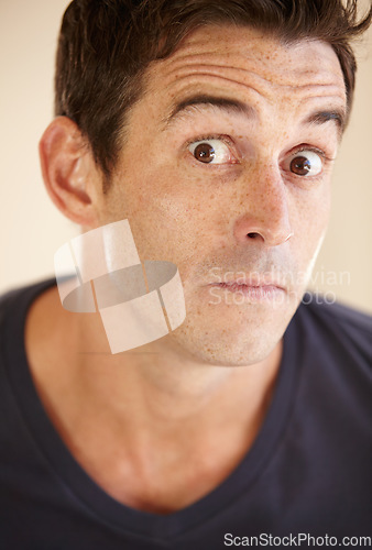 Image of Shock, comic and portrait of man in studio with funny facial expression, reaction and emotions. Emoji, humor and face closeup of person with surprise, what and omg for news on color background
