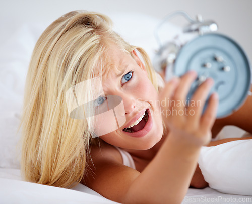 Image of Alarm, clock and woman in bed, stress and snooze to rest with anxiety, late and lady in a home. Tired, sleep and lazy with girl, appointment and person in bedroom on morning weekend, time and ignore