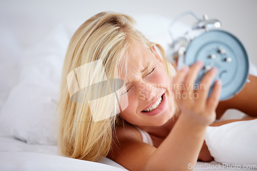 Image of Alarm, clock and woman in bed, late and snooze to rest with anxiety, frustrated and lady in a home. Tired, sleep or lazy with girl, appointment or person in bedroom on morning weekend, time or stress