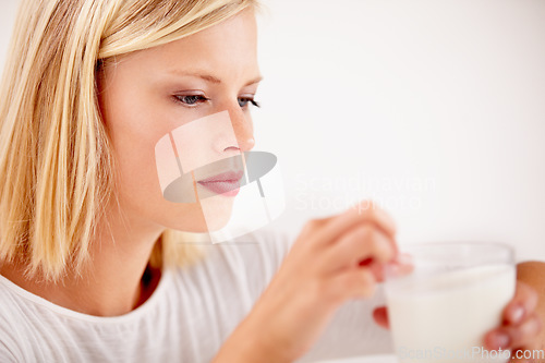 Image of Woman, drink and milk thinking for nutrition or glass, white background as studio mockup. Female person, dairy and breakfast smoothie for calcium as healthy vitality or milkshake, protein or diet