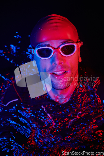 Image of authentic triathlete swimmer having a break during hard training on night neon gel light