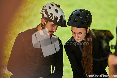 Image of A blissful couple, adorned in professional cycling gear, enjoys a romantic bicycle ride through a park, surrounded by modern natural attractions, radiating love and happiness