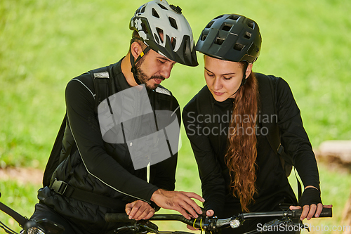 Image of A blissful couple, adorned in professional cycling gear, enjoys a romantic bicycle ride through a park, surrounded by modern natural attractions, radiating love and happiness