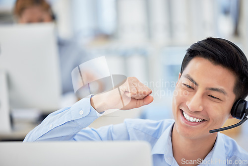 Image of Man, telemarketing and phone call celebrate happy for customer service, office work or company sale. Asian person, fist for achievement as communication employee for care, discussion at help desk