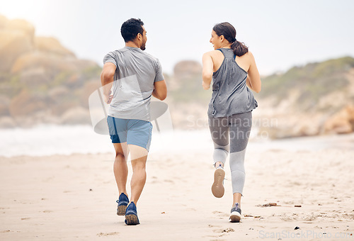 Image of Couple of friends, running and workout on beach for fitness, training and accountability with cardio, race or support. Back of people, athlete or runner by ocean, sea and outdoor for exercise health