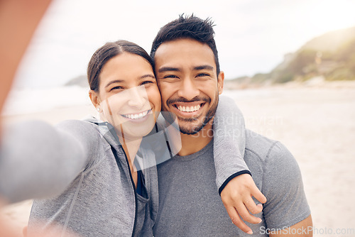 Image of Happy couple, beach and selfie in fitness for photography, memory or outdoor workout together. Portrait of man and woman smile in photograph, picture or social media vlog on ocean coast for exercise