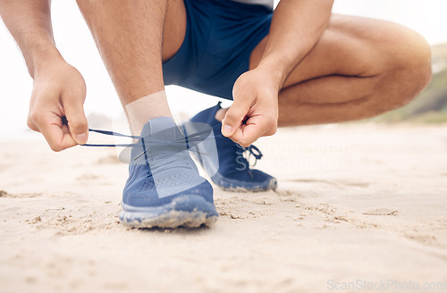 Image of Running shoes, hands and fitness man at a beach for training, exercise or morning cardio zoom. Legs, closeup and male runner with sneakers lace outdoor for wellness, workout or marathon practice run