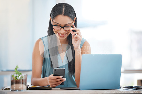 Image of Happy business woman, laptop and phone for communication, networking or social media at office. Female person or employee smile on mobile smartphone in online chatting, texting or search at workplace