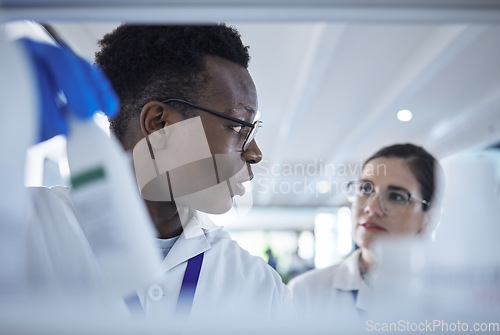Image of People, scientist or team checking inventory in lab for experiment, sample bottle or chemical. Young man and woman in teamwork together for science research, stock check or product test at laboratory