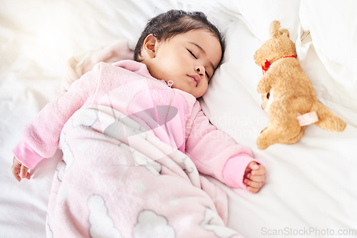 Image of Baby, sleeping and girl in bed with teddy bear, animal and peace in home with blanket and comfort. Child, rest and sleep in morning, nap and routine for health, wellness and calm face of infant